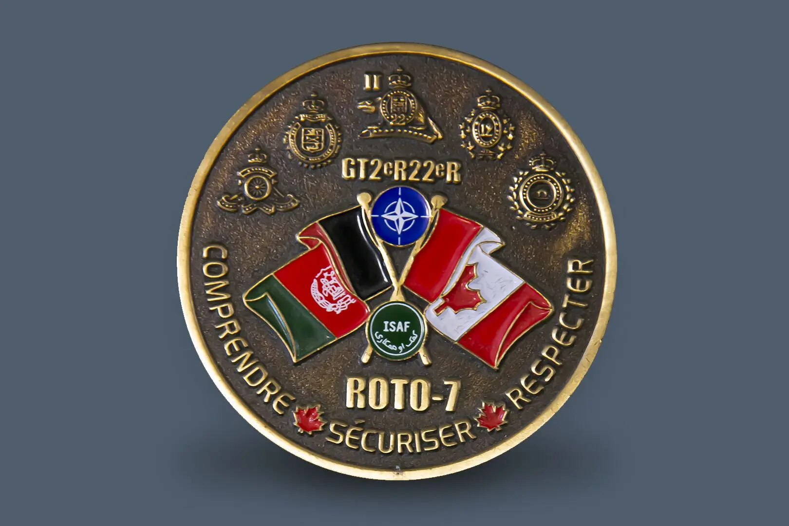 Médaillon de bronze avec le drapeau canadien et celui de l’Afghanistan entrecroisés au centre. Entre les deux drapeaux, le logo bleu de l’OTAN surmonté des lettres et chiffres GT2ième R22ièmeR (Groupe tactique du 2e Bataillon, Royal 22e Régiment). Un peu plus bas, on trouve le logo de la Force internationale d’assistance à la sécurité (ISAF). En dessous de ce dernier, la mention ROTO 7 pour la Rotation 7 est indiquée. Au bas du médaillon, trois mots apparaissent, tous séparés par des feuilles d’érable rouges&nbsp;: comprendre, sécuriser, respecter. Dans le haut du médaillon, on trouve cinq insignes d’unités ayant participé à l’opération ATHENA. 
