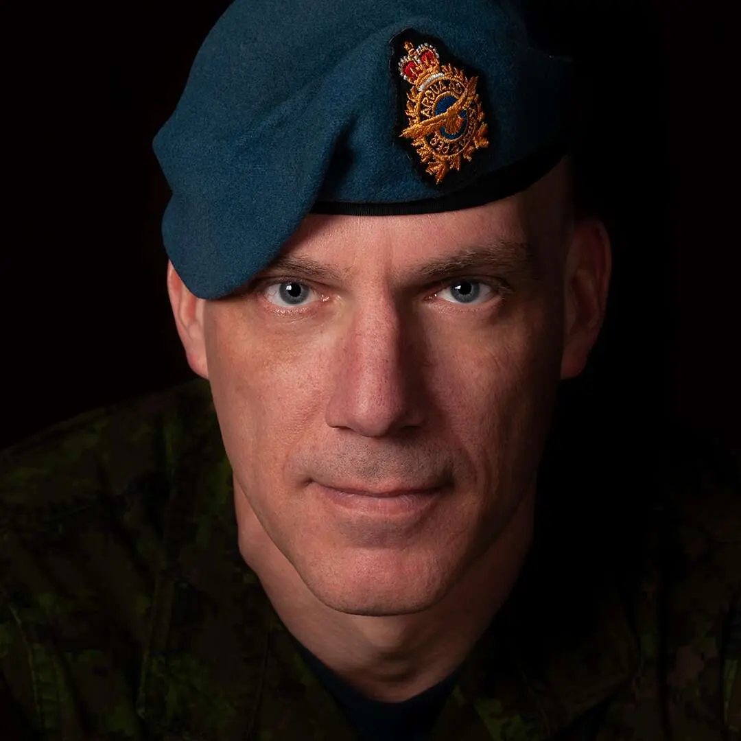 Sur un fond noir, on voit le caporal Martin Lafontaine. Son visage est oblong et anguleux. Ses yeux sont gris. Il porte le béret bleu de l’Aviation royale canadienne et regarde la caméra avec un air sérieux.