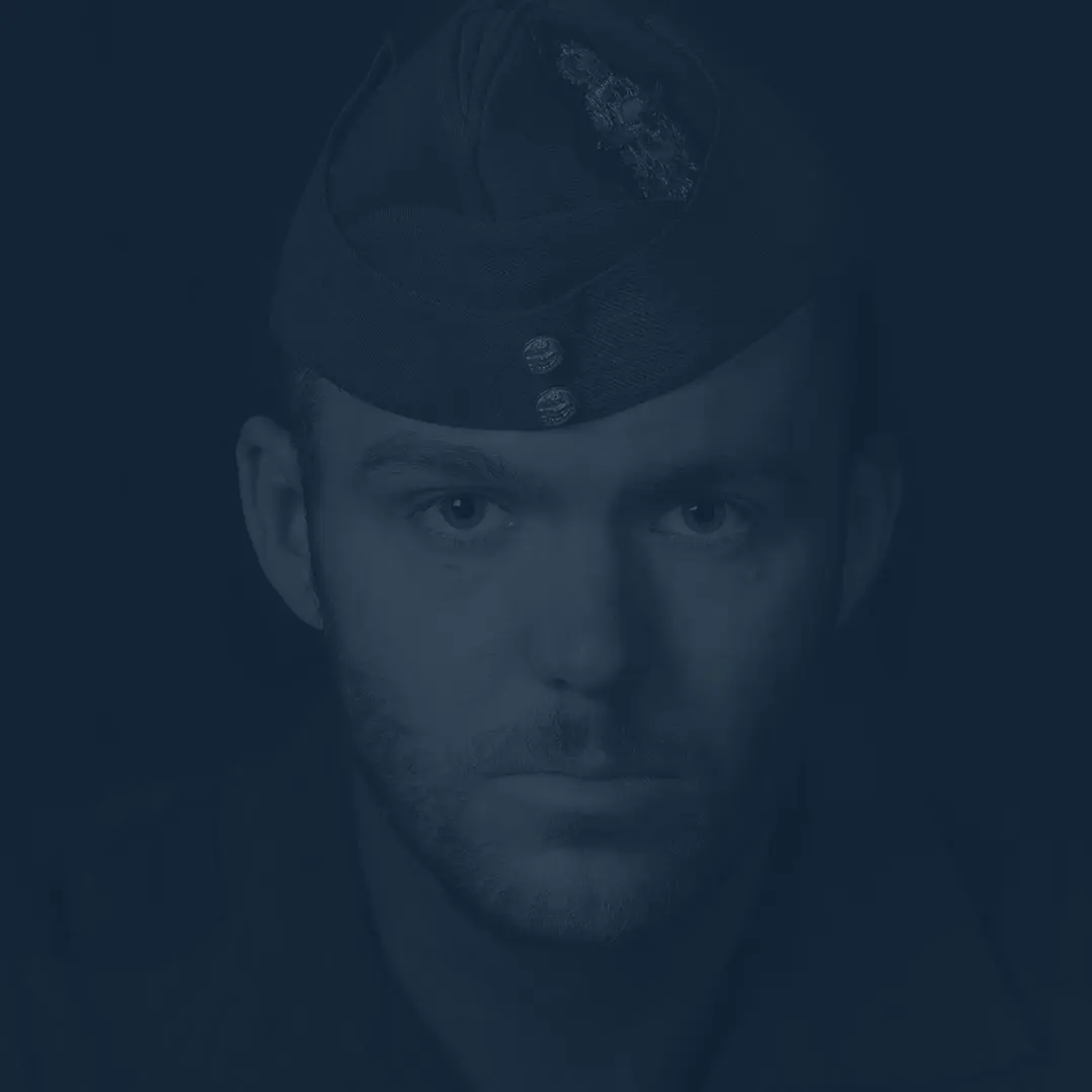 Sur un fond noir, portant le calot bleu roi de l’Aviation royale canadienne et affichant une barbe claire, le capitaine DHG fait face à la caméra avec un regard impénétrable. 