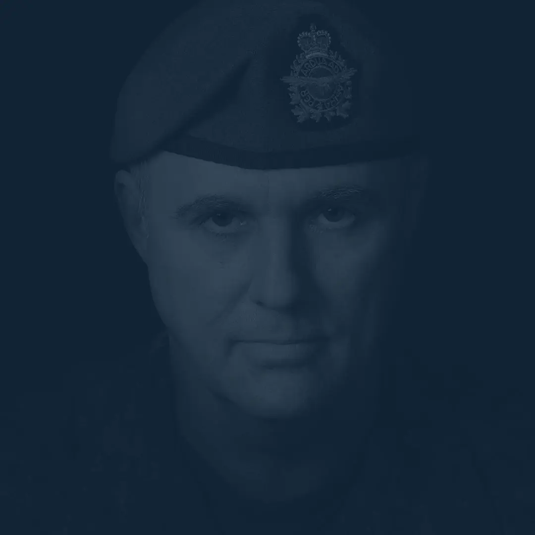 Sur un fond noir, le caporal Bernard Lachapelle regarde la caméra sérieusement. Il possède un visage triangulaire et porte un béret bleu de l’Aviation royale canadienne dissimulant ses tempes grisonnantes.