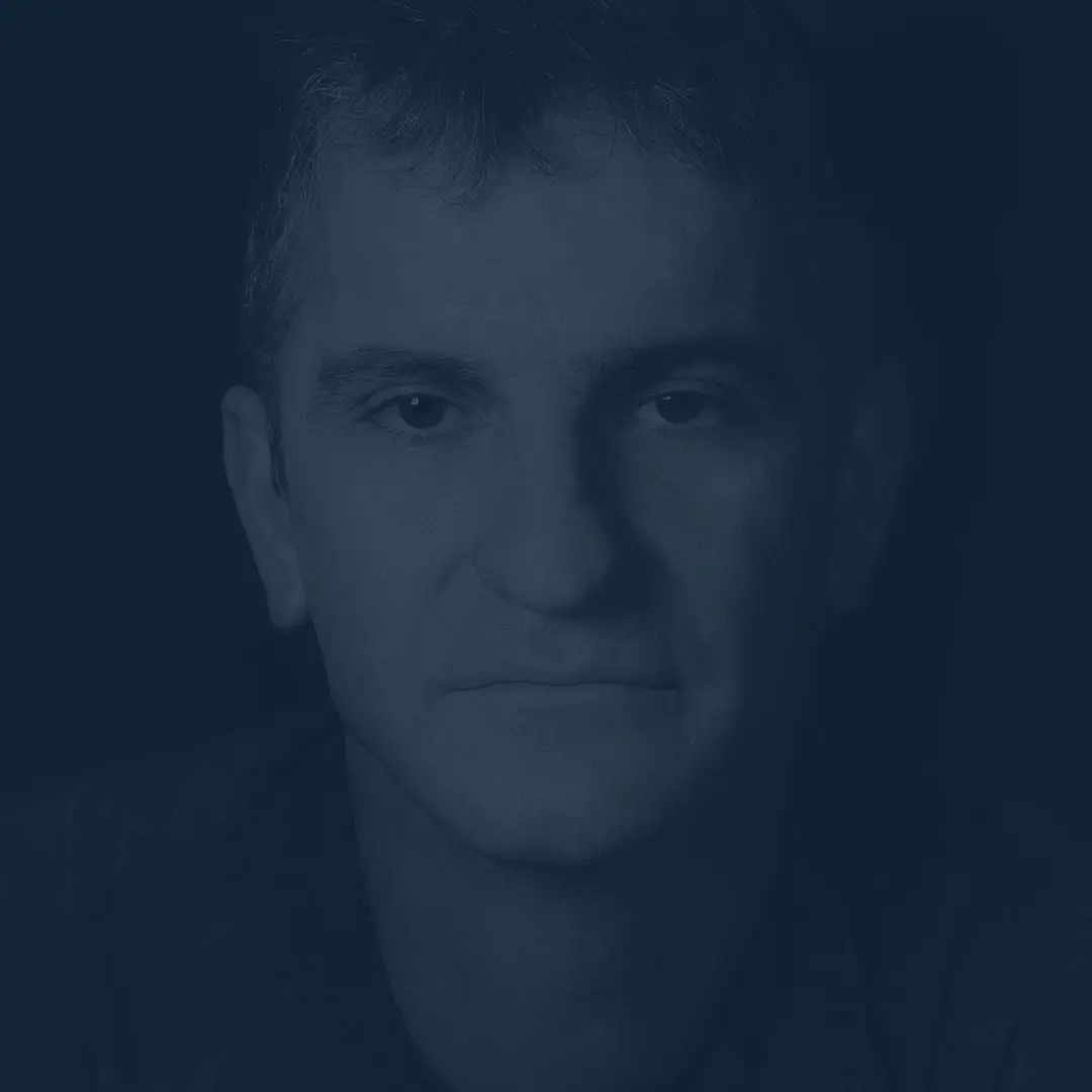 Sur un fond noir, l’adjudant Éric Henry, cheveux foncés, légèrement grisonnants, demeure impassible devant la caméra. 