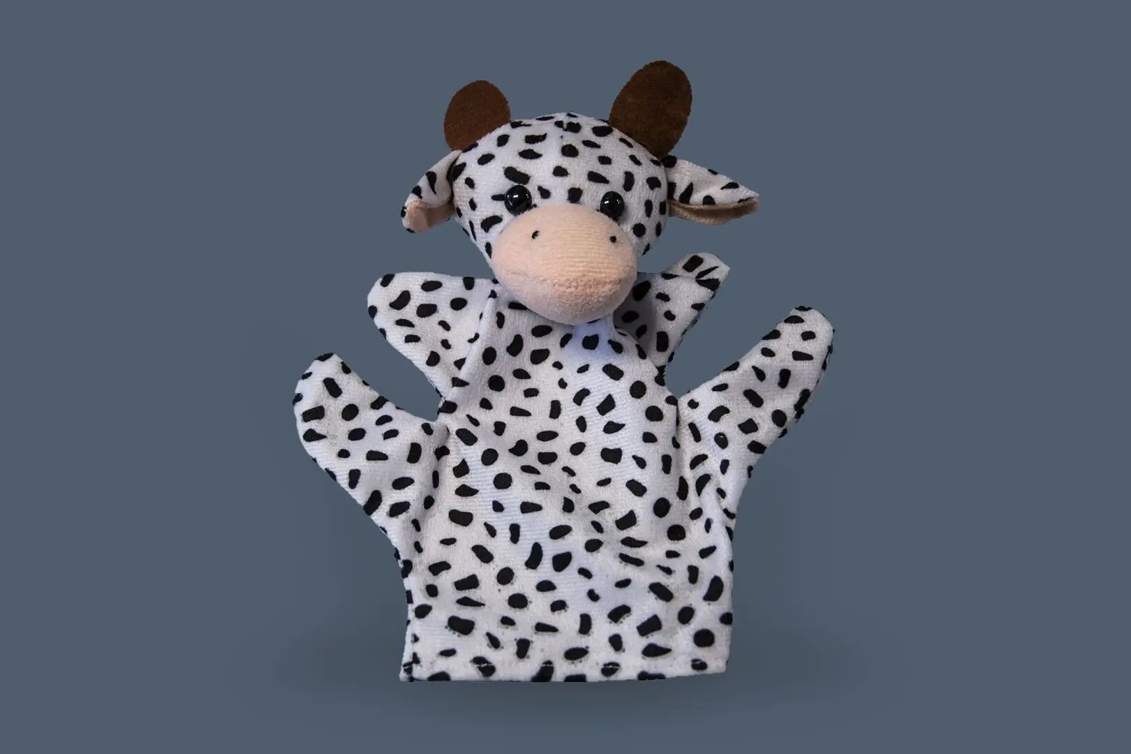 Petite marionnette représentant une vache blanche tachetée de points noirs offerte aux enfants lituaniens.